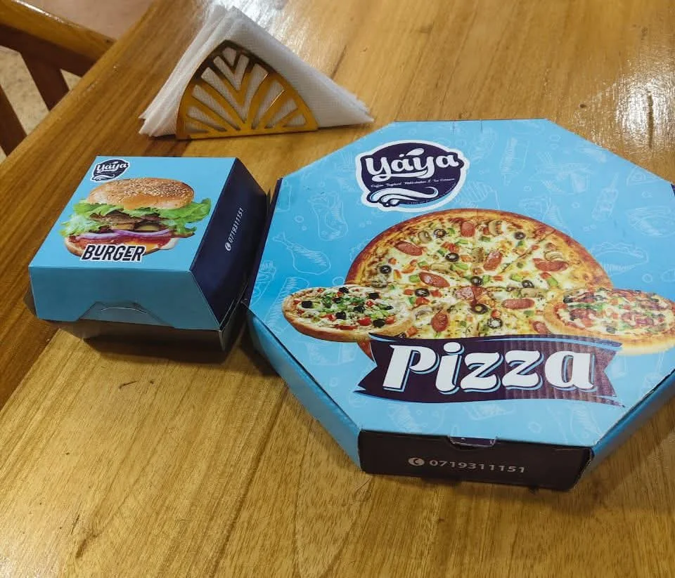 Original Yaya Pizzeria packaging: smaller turquoise burger box on the left and large turquoise pizza box on the right